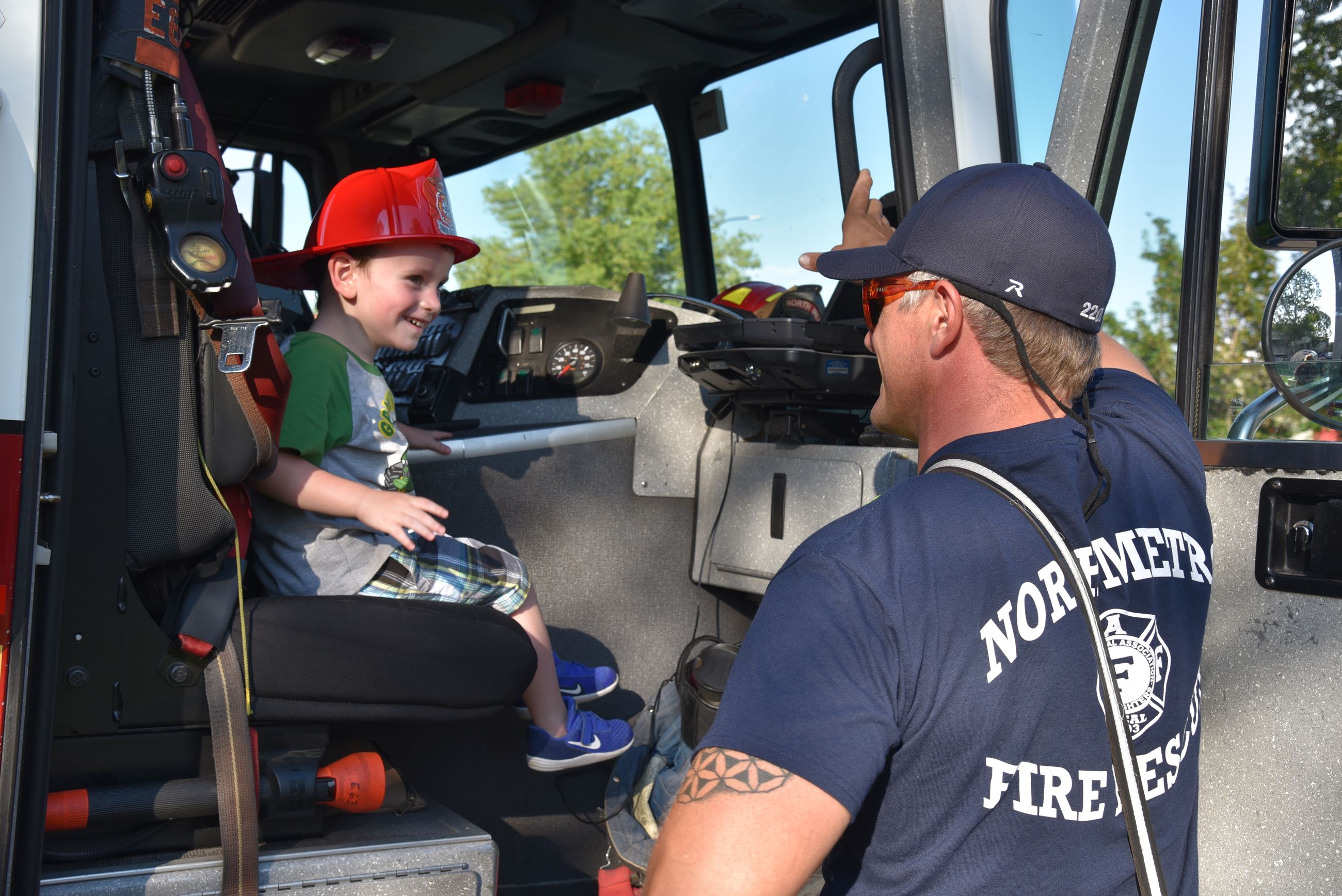 Firefighter giving engine tour to child